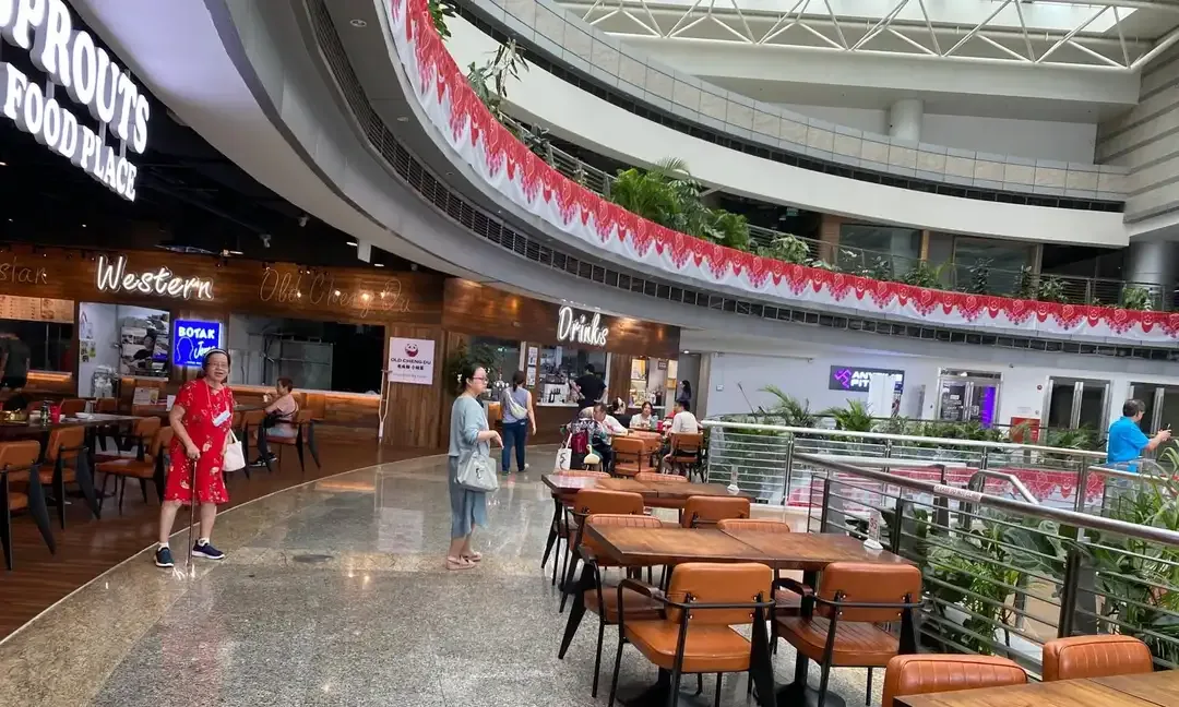 Inside Sprouts Food Place at The JTC Summit, wooden stall fronts and long tables